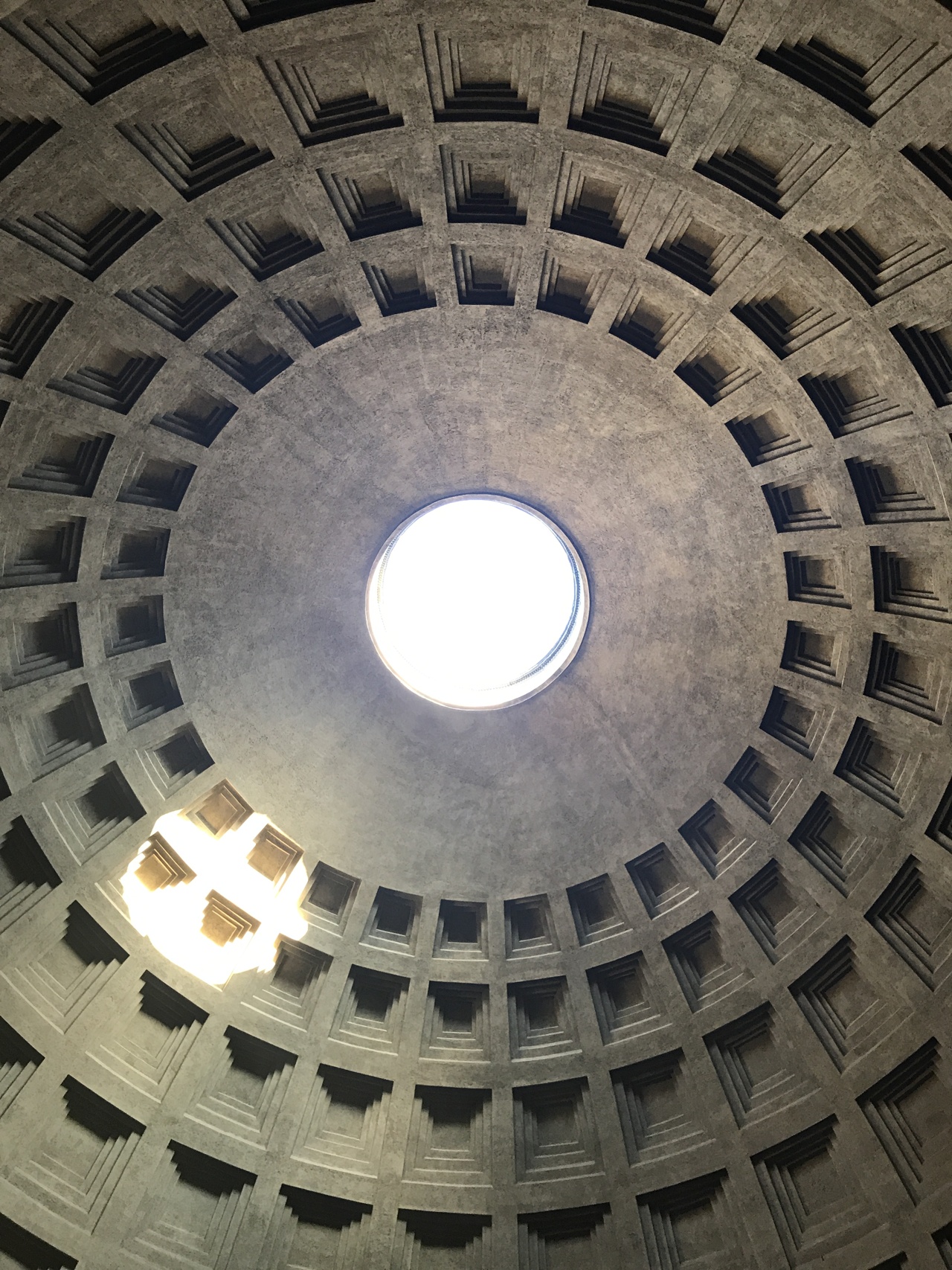 The image shows the interior dome of the Pantheon with a circular opening at the top.